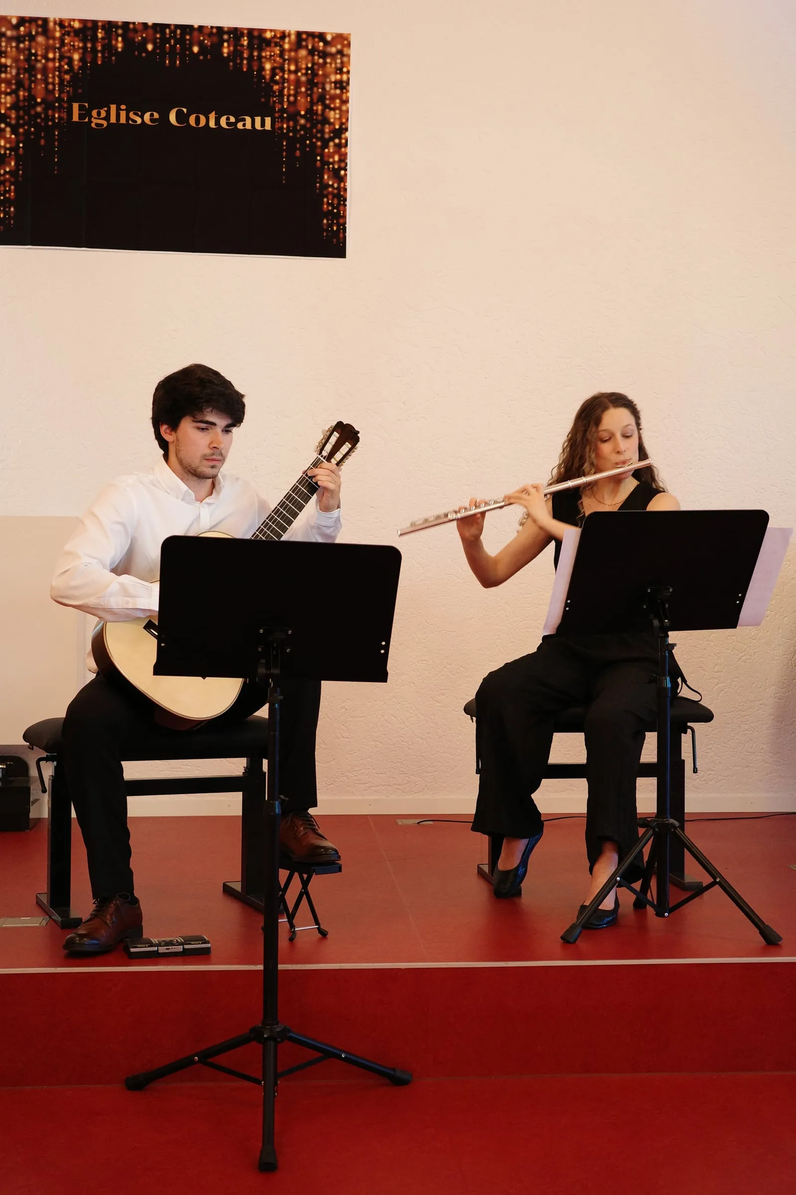 Miguel Ferreira and flautist Leonor Moreira in concert, beneath the Église du Coteau banner.
